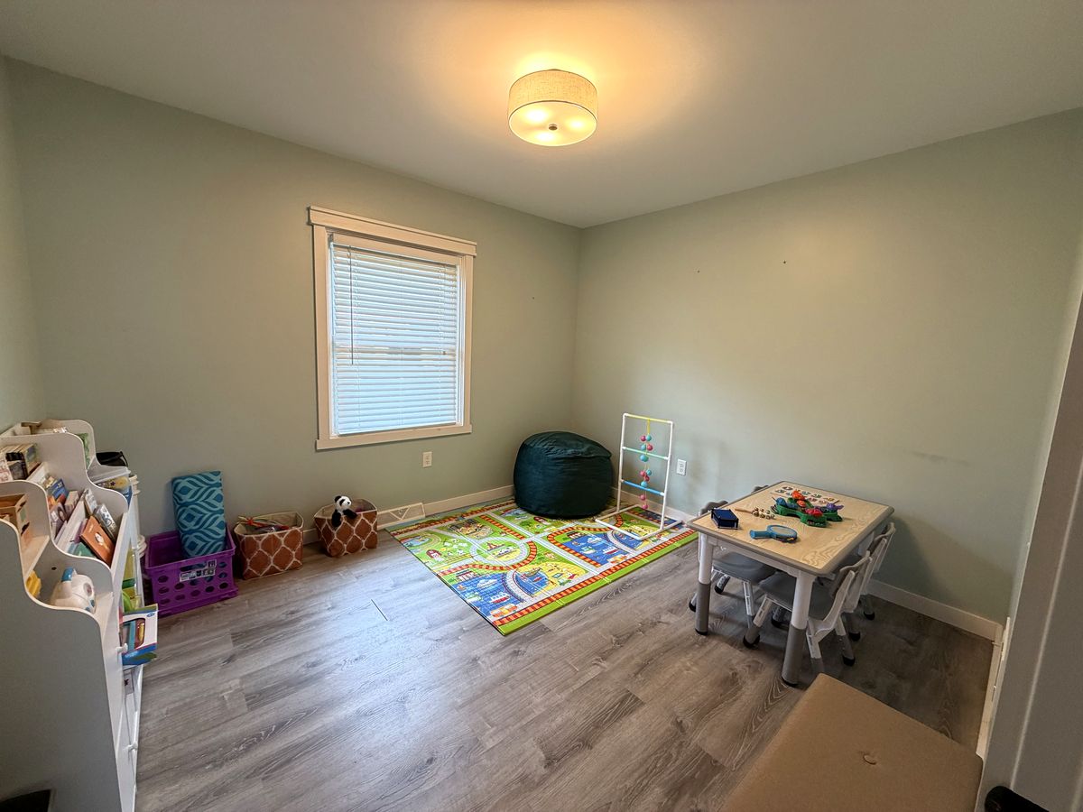 Play room with a colorful floor mat and toys